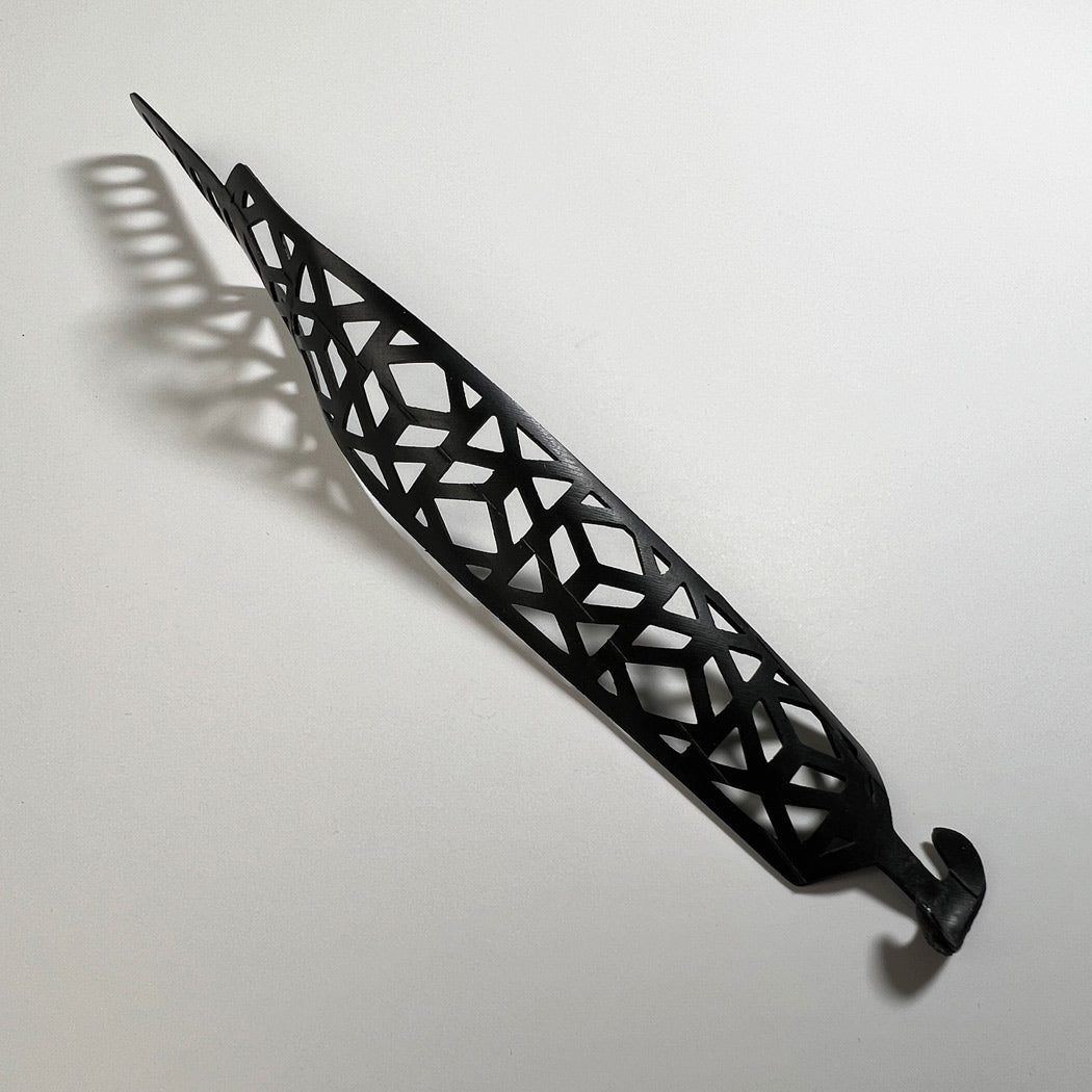 This bracelet was made by cutting intricate designs into a bicycle inner tube. It looks like a criss cross vine in a repeat pattern. It has a tribal feel to it.  It is about 1.2 inches wide. It has a t-shape clasp that fits into one of six holes making this bracelet suitable for a wide range of wrist sizes.