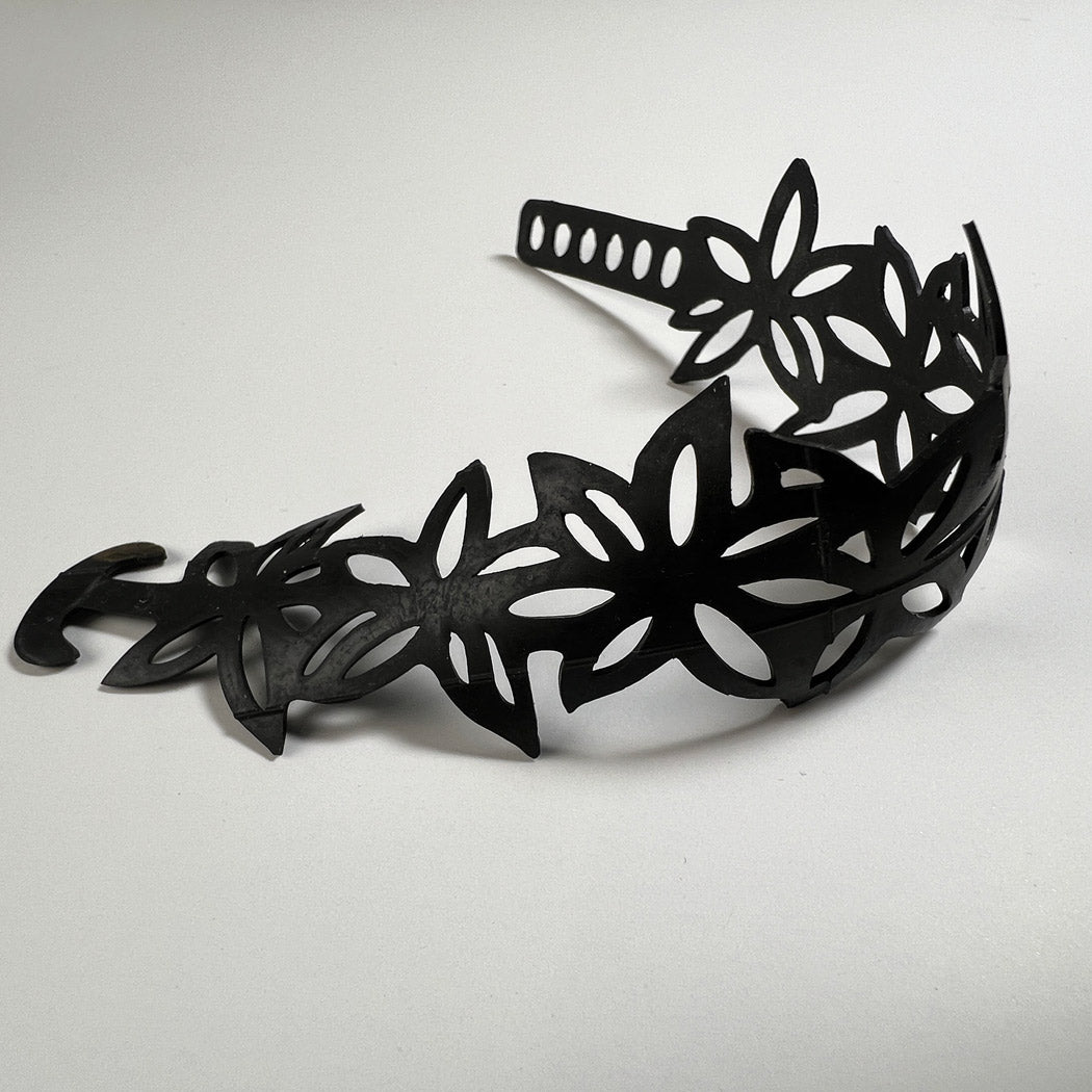 This bracelet was made by cutting intricate designs into a bicycle inner tube. This bracelet features a series of flowers with five petals making it 1.25 inches wide. It has a t-shape clasp that fits into one of six holes making this bracelet adjustable and suitable for a wide range of wrist sizes.